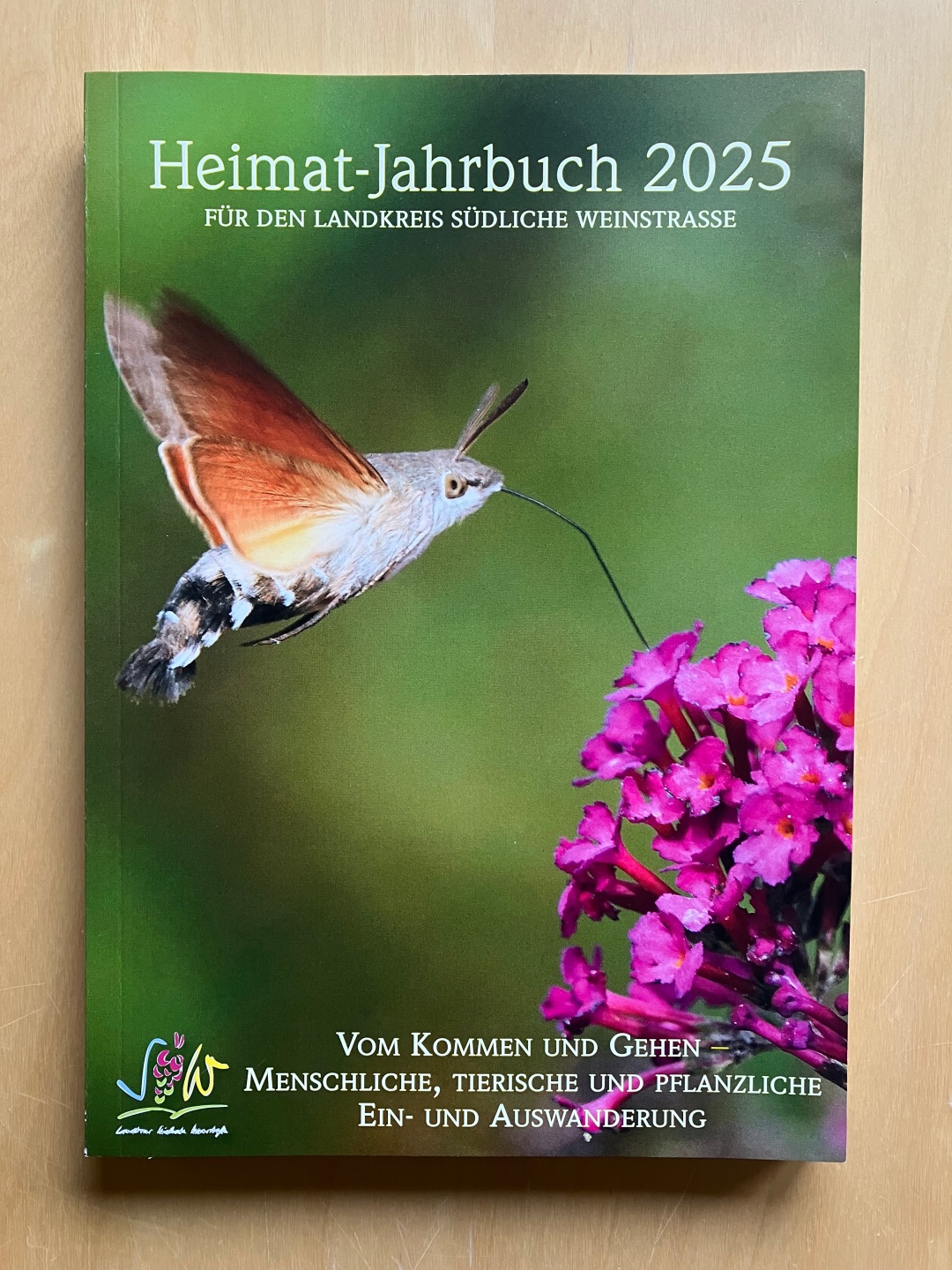 Das Heimat-Jahrbuch 2025 des Landkreises Südliche Weinstraße. Auf dem Cover ist eine Nahaufnahme eines Insekt zu sehen: Ein Taubenschwänzchen beim Anflug auf einen Sommerflieder.