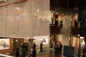 Menschen auf zwei Stockwerken im Kreishaus betrachten Kunstwerke. 