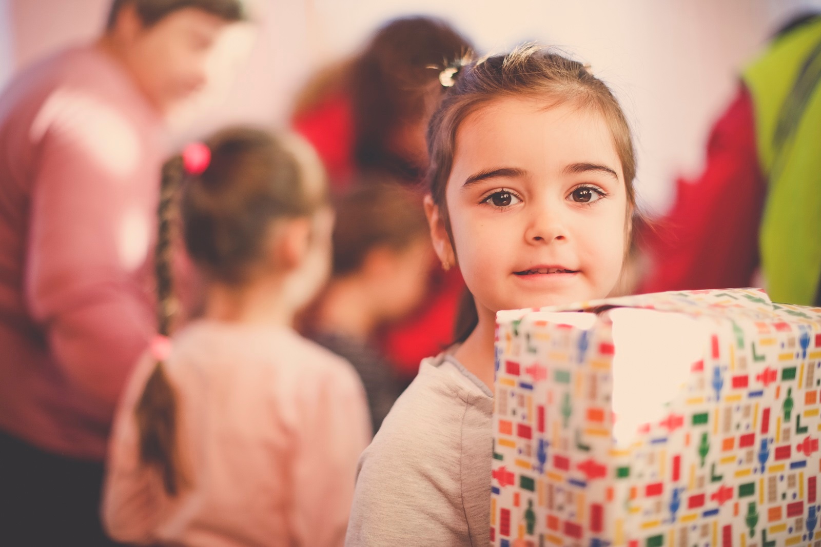 Ein Mädchen hält ein verpacktes Geschenk, 