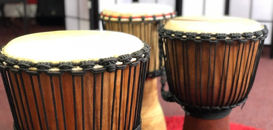Drei Trommeln stehen auf einem Teppich. 