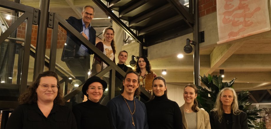 Eine Gruppe Menschen steht auf der Treppe im Foyer des Kreishauses SÜW. 