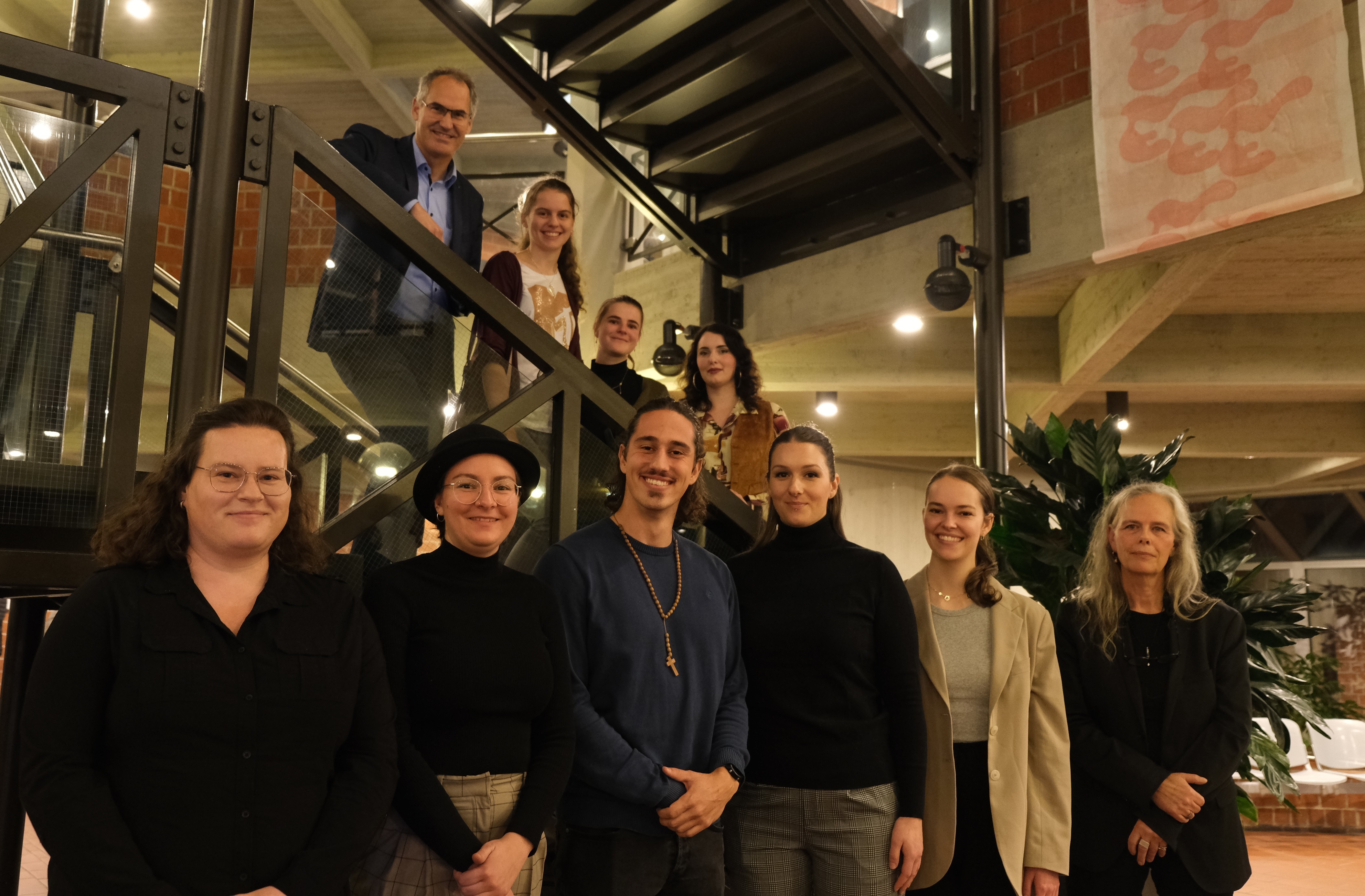 Eine Gruppe Menschen steht auf der Treppe im Foyer des Kreishauses SÜW. 