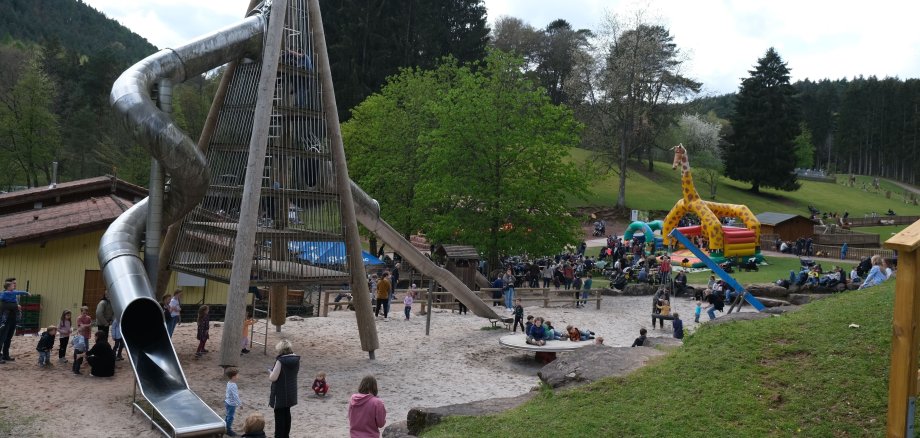 Spielplatz mit Riesenrutsche, im Hintergrund eine Hüpfburg.