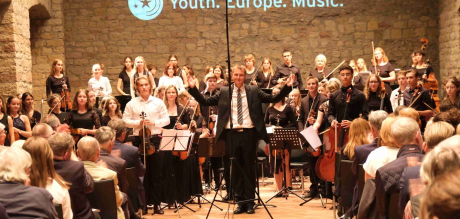 Das trinationale Orchester des Projekts „Youth. Europe. Music.“ unter Marc Bender (in der Mitte) bei einem Auftritt auf dem Hambacher Schloss. Foto: KV SÜW