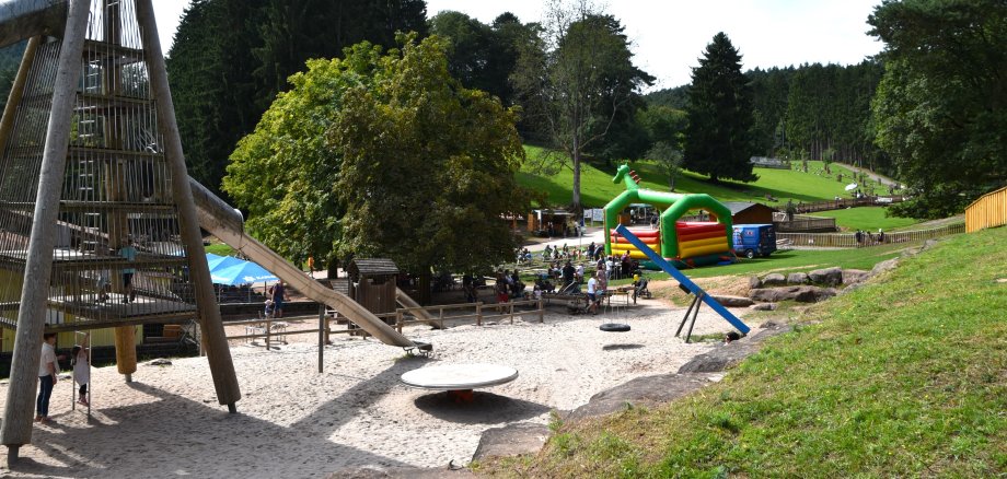 Neben dem Spielplatz des Wild- und Wanderparks steht eine große Hüpfburg auf der Wiese.