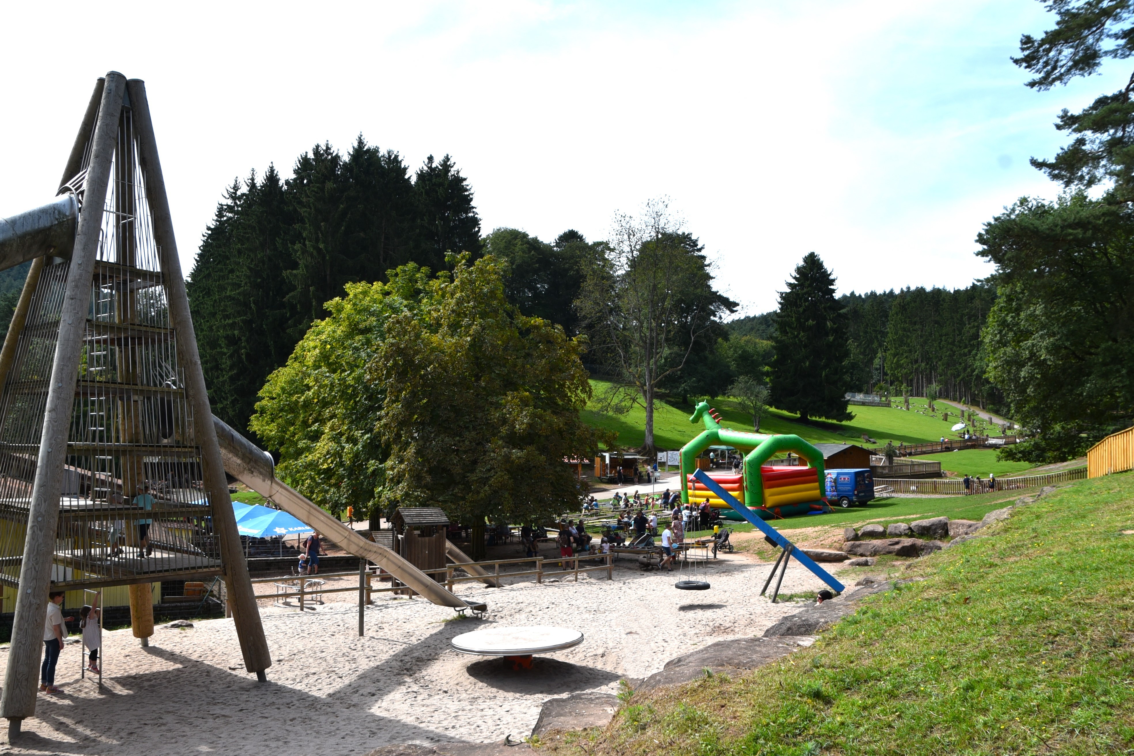 Neben dem Spielplatz des Wild- und Wanderparks steht eine große Hüpfburg auf der Wiese.