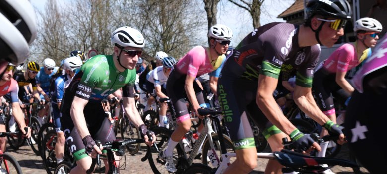 Am 25. August ist Radsport der Extraklasse zu erleben. Das Archivbild zeigt den Start eines anderen Rennens in SÜW, des Großen Preises der Südlichen Weinstraße. Foto: KV SÜW Mehrere Radrennfahrer in farbigen Trikots während des Starts eines Rennens auf einer gepflasterten Straße.