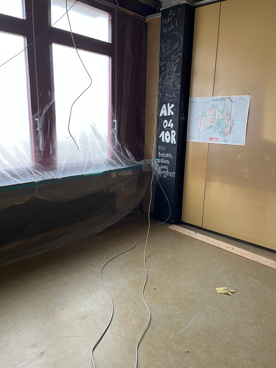 Ein Klassenraum im Alfred-Grosser-Schulzentrum in Bad Bergzabern. Kabel hängen von der Decke, der Boden ist leergeräumt, und Fenster sind mit Plastikfolie abgedeckt.