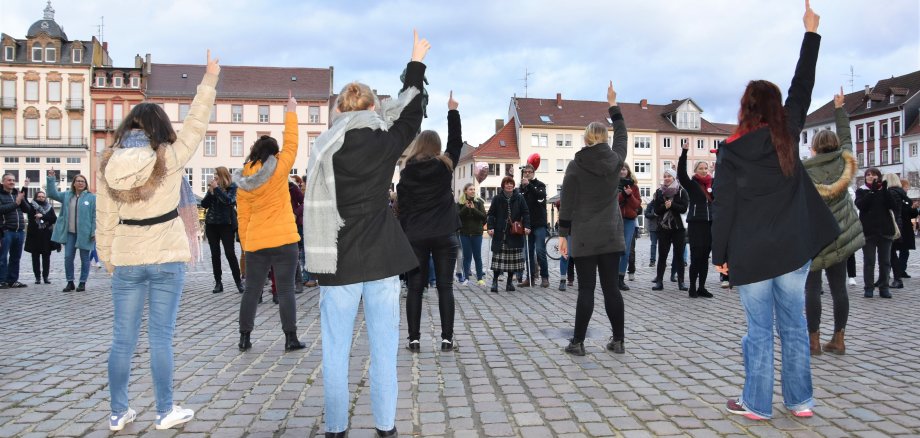 Viele Frauen tanzen auf dem Rathausplatz in Landau und recken die Hände in die Luft.