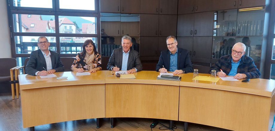 Bei der Unterzeichnung der Vereinbarung über die Tagespflegeeinrichtung in Maikammer sitzen nebeneinander an einem halbrunden Tisch Christian Rohatyn (Geschäftsführer Gemeinnütziges Siedlungswerk Speyer GmbH), Gabriele Flach (Bürgermeisterin Verbandsgemeinde Maikammer), Karl Schäfer (Ortsbürgermeister Maikammer), Landrat Dietmar Seefeldt, Olaf Kleinschmidt (Vorsitzender der Ökumenischen Sozialstation Neustadt). 