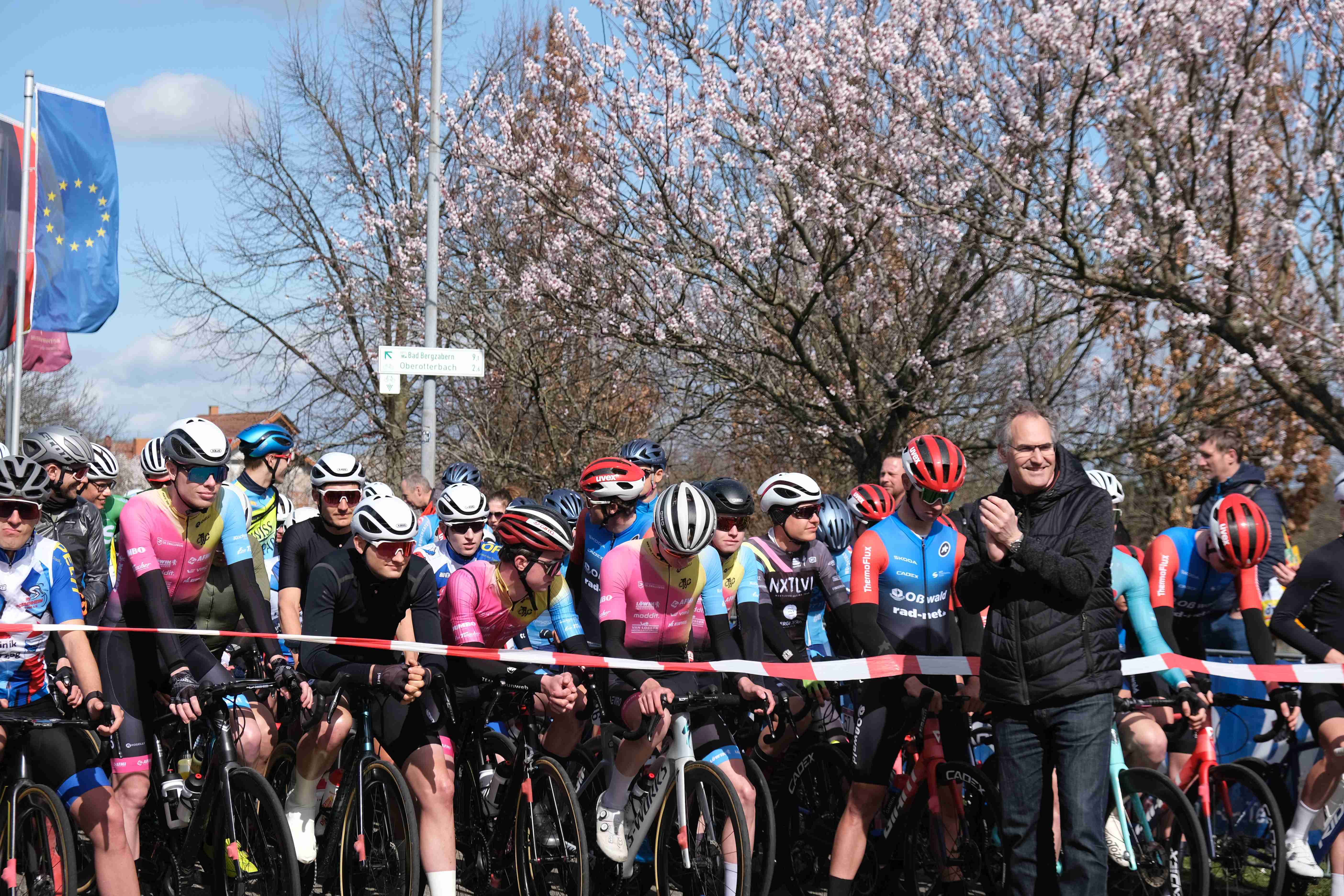 Ein rotes Band trennt den Landrat von dem wartenden Fahrerfeld. 