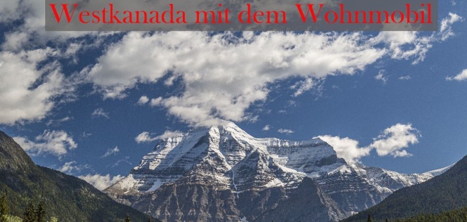 Bergmassiv hinter kanadischen Wäldern im Sonnenschein. In roter Schrift steht Westkanada mit dem Wohnmobil.