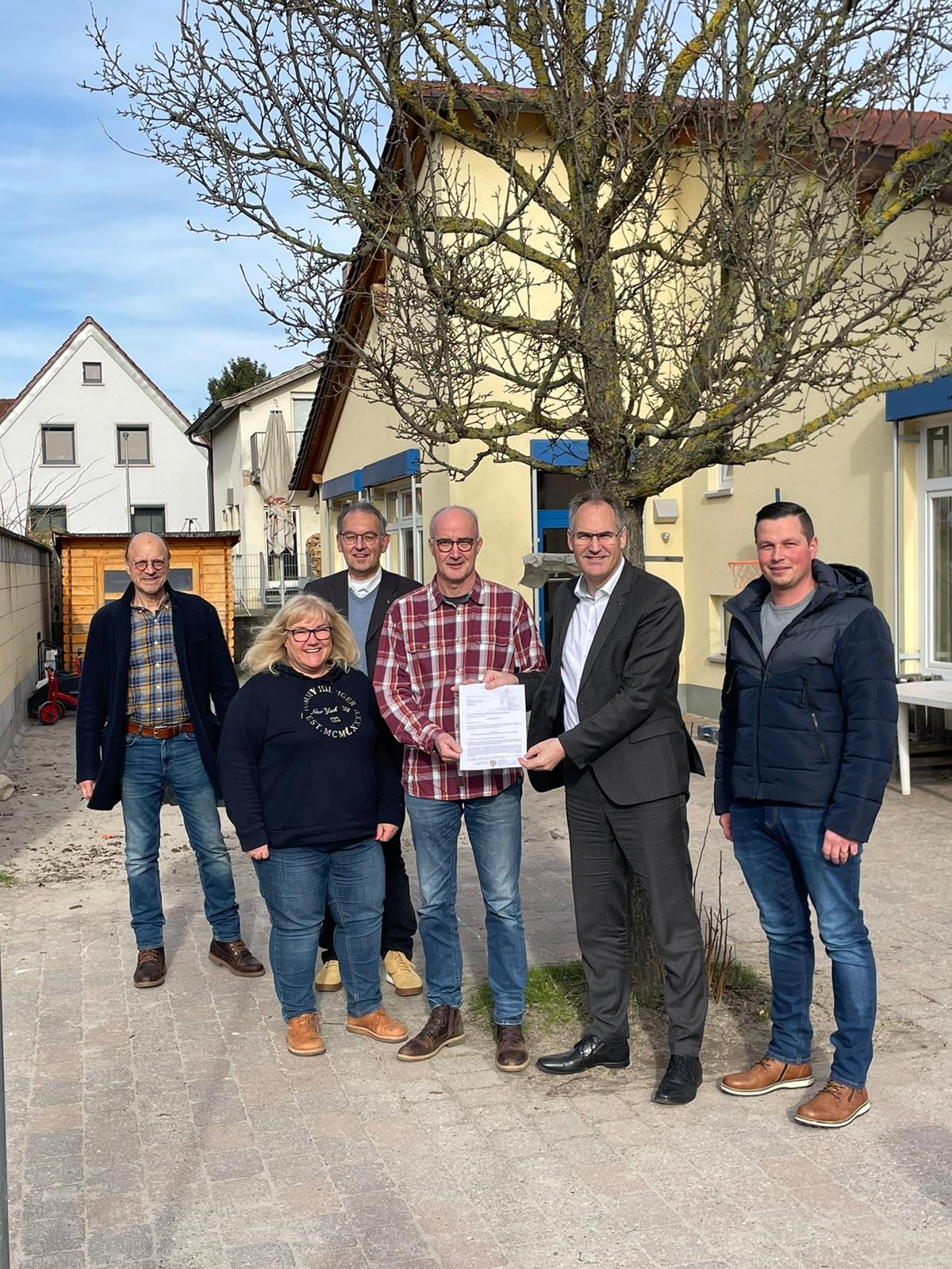 Landrat Dietmar Seefeldt übergab Ortsbürgermeister Jürgen Leibfried (Mitte) den Förderbescheid. Mit im Bild vor der Kita St. Georg: Ortsbeigeordneter Georg Wiedemann, Kita-Leiterin Anke Bruckner, Erster Kreisbeigeordneter Georg Kern und Ratsmitglied Florian Hund.