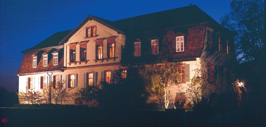 Das von innen und außen beleuchtete Herrenhaus in Edenkoben bei Nacht.