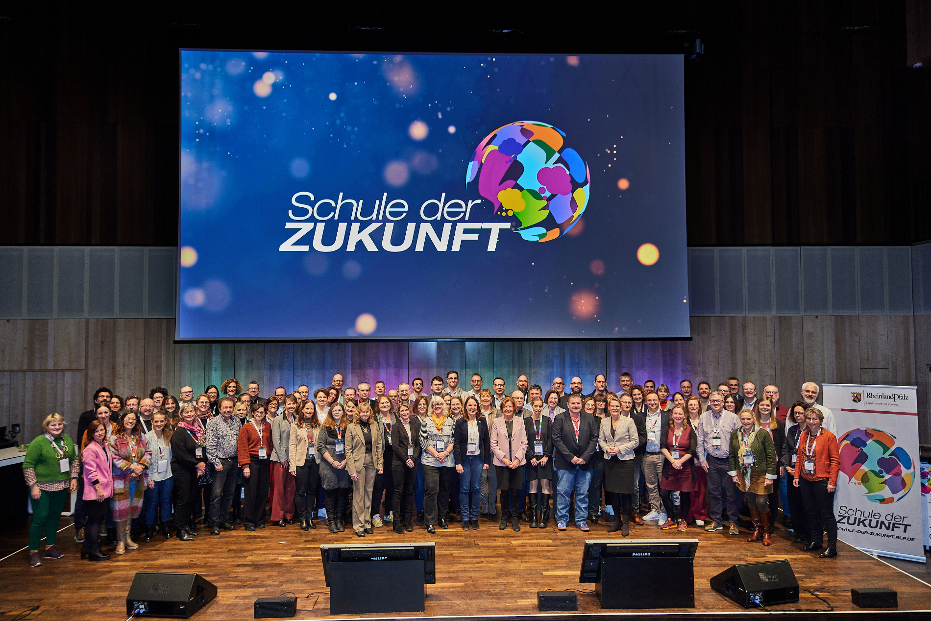 Gruppenaufnahme auf einer Bühne. 