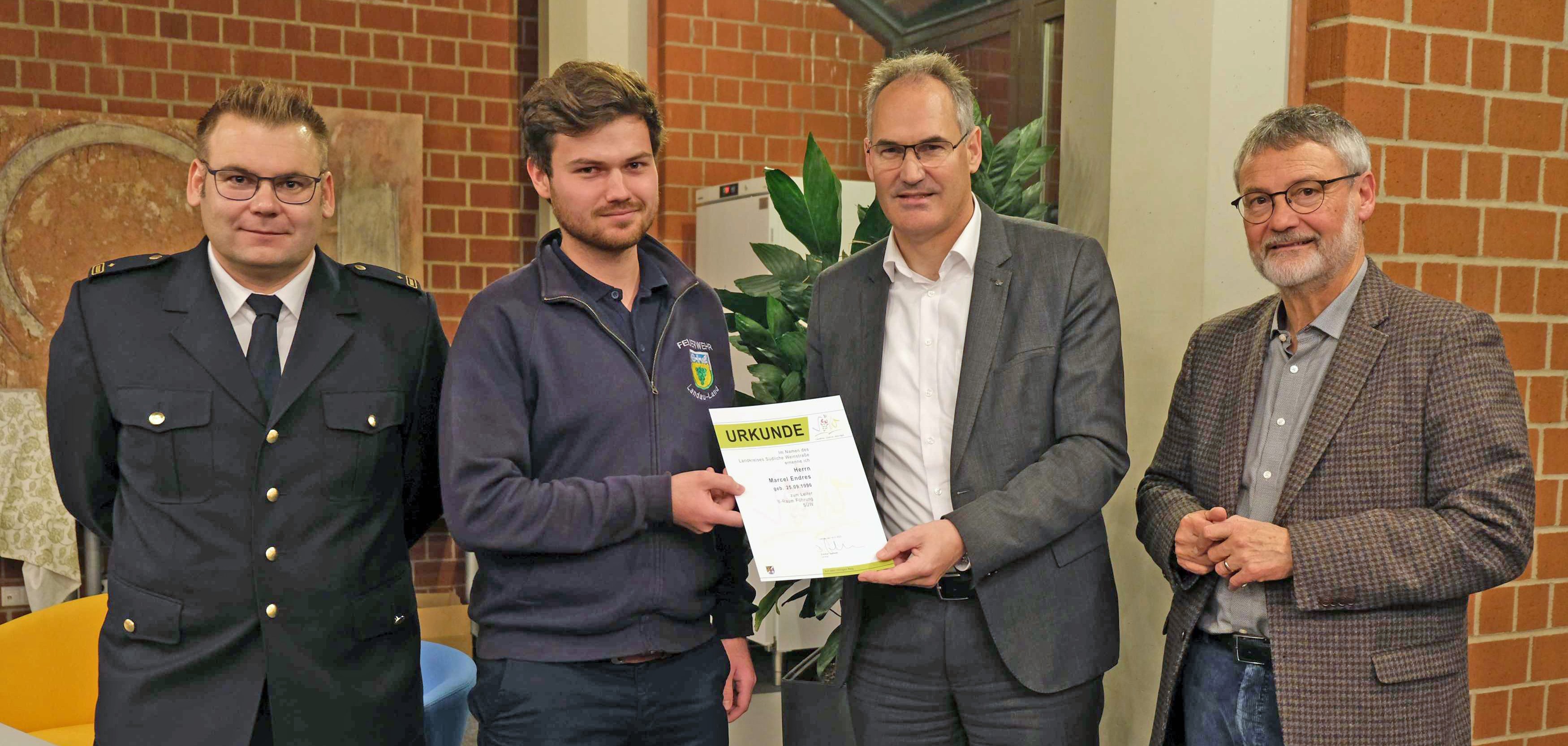 Marcel Endres erhielt von Landrat Dietmar Seefeldt eine Urkunde. Mit auf dem Bild: Brand- und Katastrophenschutzinspekteur der Südlichen Weinstraße, Jens Thiele (links), und der für den Brand- und Katastrophenschutz zuständige Kreisbeigeordnete Kurt Wagenführer.