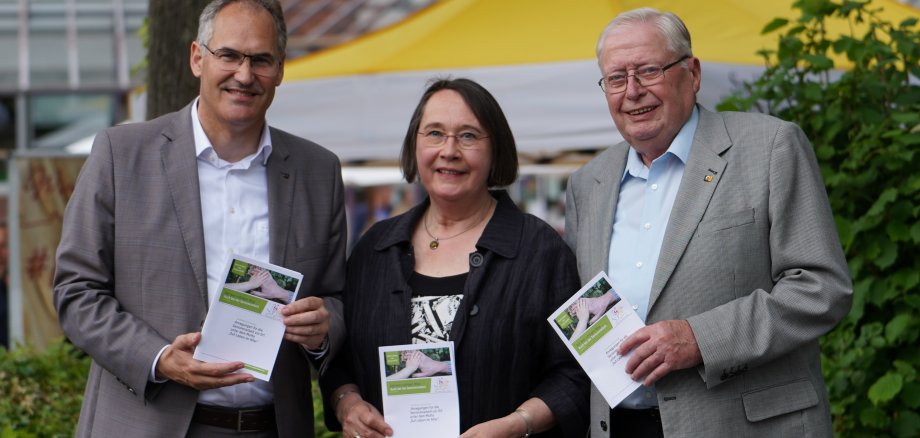 Landrat Dietmar Seefeldt, Dr. Ingrid Sebastian-Sehr und Alexander von Rettberg vom Vorstand des Kreisseniorenbeirats 2019 bis 2024 präsentieren die neue Informationsbroschüre des Kreisseniorenbeirats beim Kreisempfang. Herbert Schulz, ebenfalls Vorstandsmitglied der Legislaturperiode 2019 bis 2024, fehlt auf dem Bild.