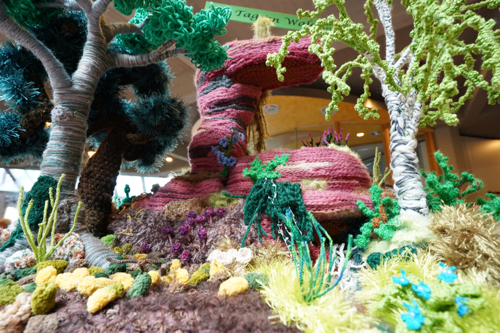 Eine bunte Waldlandschaft, gefertigt aus Häkelgarn.