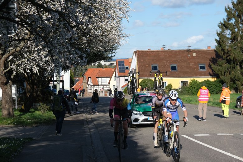 Ortsdurchfahrt Schweigen-Rechtenbach mit Fahrerfahren, Fußgängern und einem Auto.