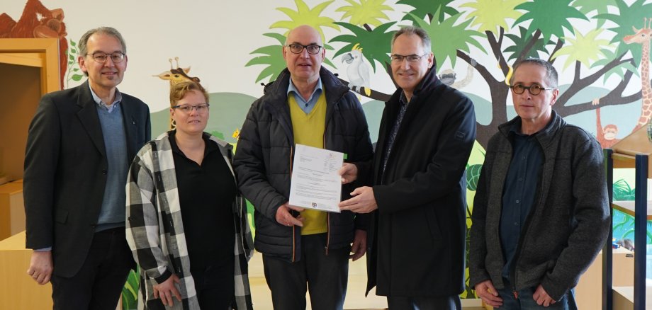 Übergabe des Förderbescheids in der Kita „Drei Freunde“. Zu sehen sind von links nach rechts der Erste Kreisbeigeordnete Georg Kern, die stellvertretende Kitaleiterin Sabine Reidt, der Erste Ortsbeigeordnete Horst Junker sowie Landrat Dietmar Seefeldt und Architekt Jürgen Thalmann.  