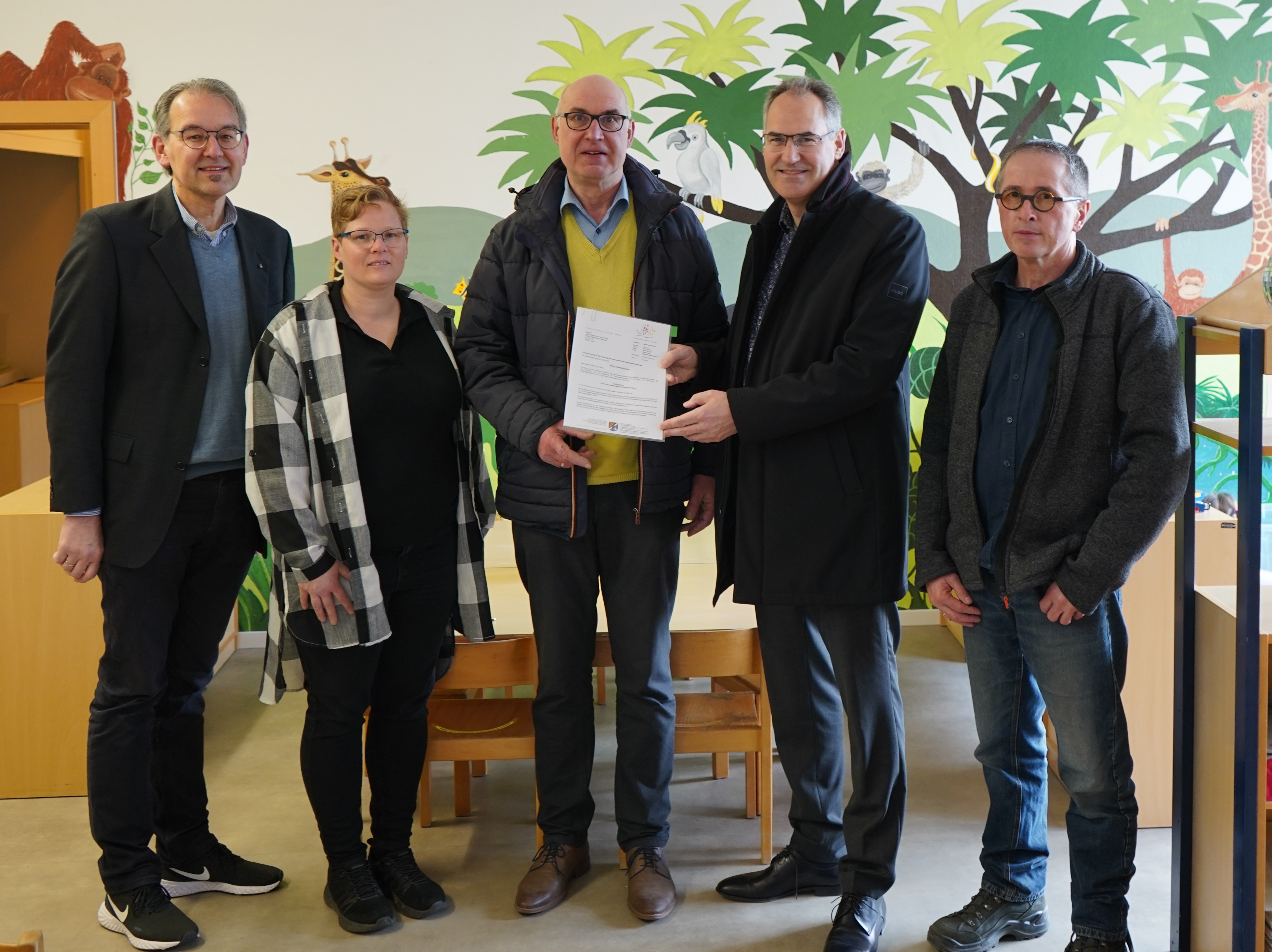 Übergabe des Förderbescheids in der Kita „Drei Freunde“. Zu sehen sind von links nach rechts der Erste Kreisbeigeordnete Georg Kern, die stellvertretende Kitaleiterin Sabine Reidt, der Erste Ortsbeigeordnete Horst Junker sowie Landrat Dietmar Seefeldt und Architekt Jürgen Thalmann.  