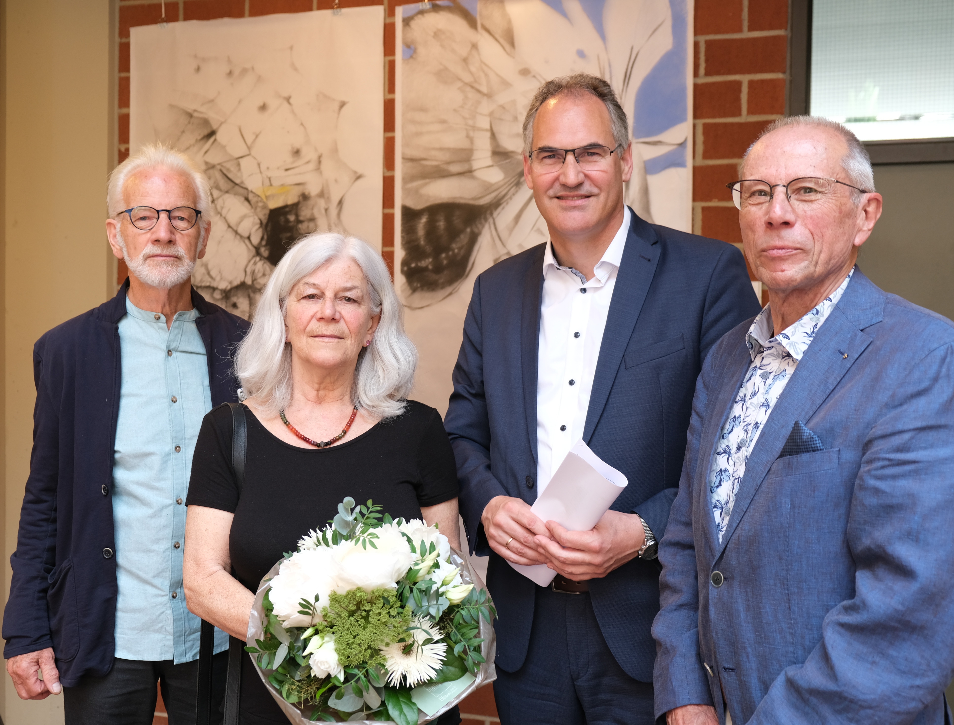 Die Künstler Rob Jansen und Carmen Stahlschmidt stehen mit Landrat Dietmar Seefeldt und Dr. Carlo Servatius, Vorsitzender der Eberhard und Barbara Linke Stiftung, vor einem Gemälde von Carmen Stahlschmidt.