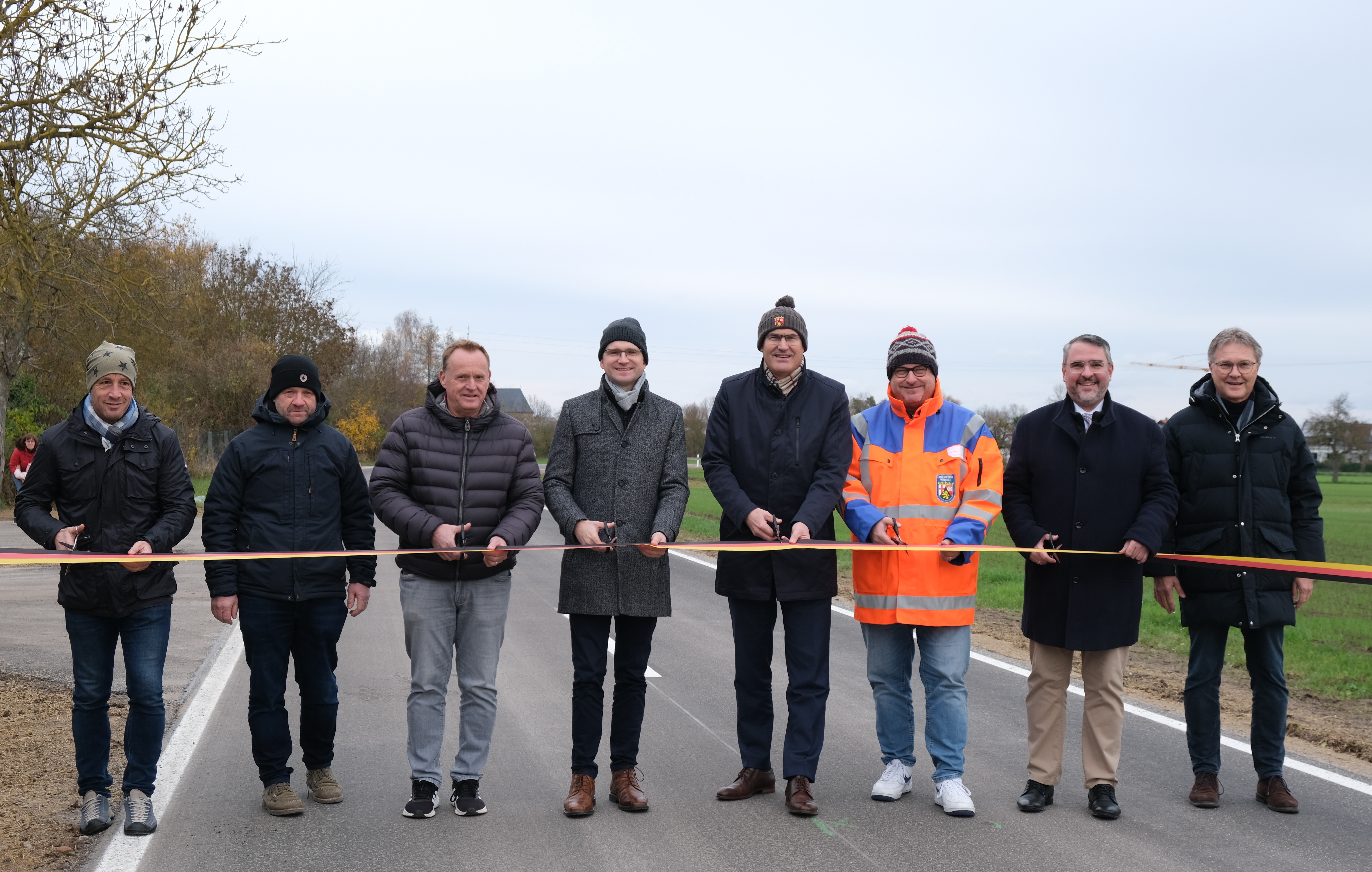 Sieben Personen stehen auf der Fahrbahn, über die ein schwarz-rot-goldendes Band gespannt ist.