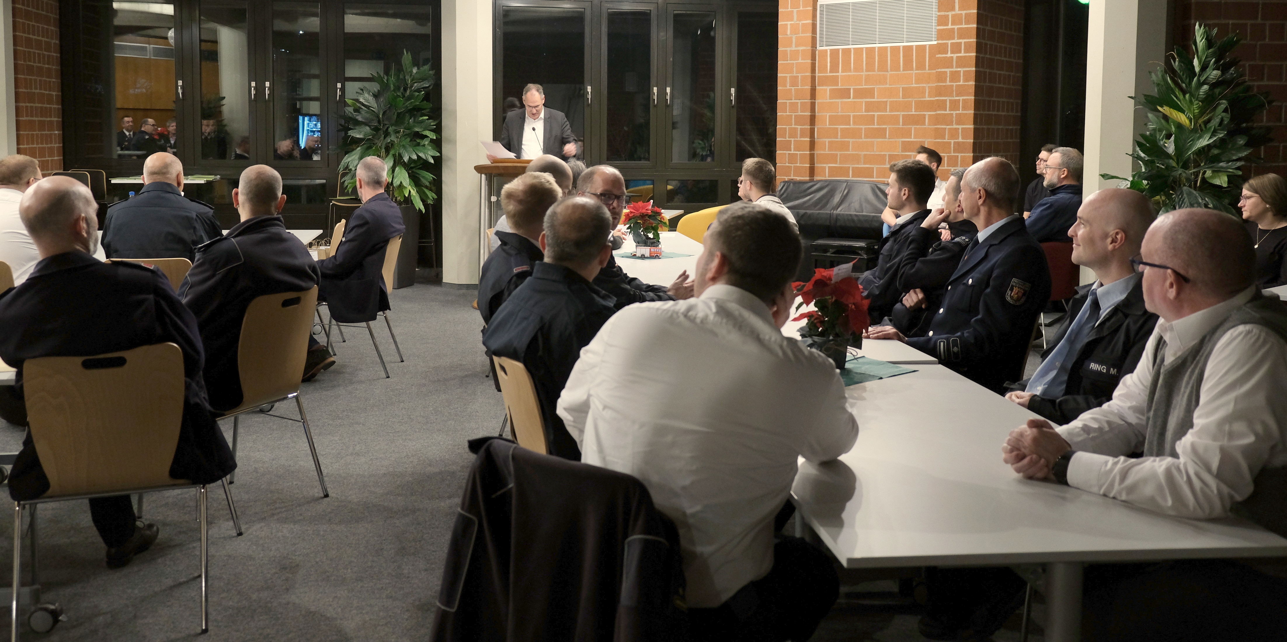 Im Hintergrund steht Landrat Dietmar Seefeldt an einem Pult, davor sitzen Führungskräfte des Brand- und Katastrophenschutzes des Kreises und der Stadt Landau an Tischen.