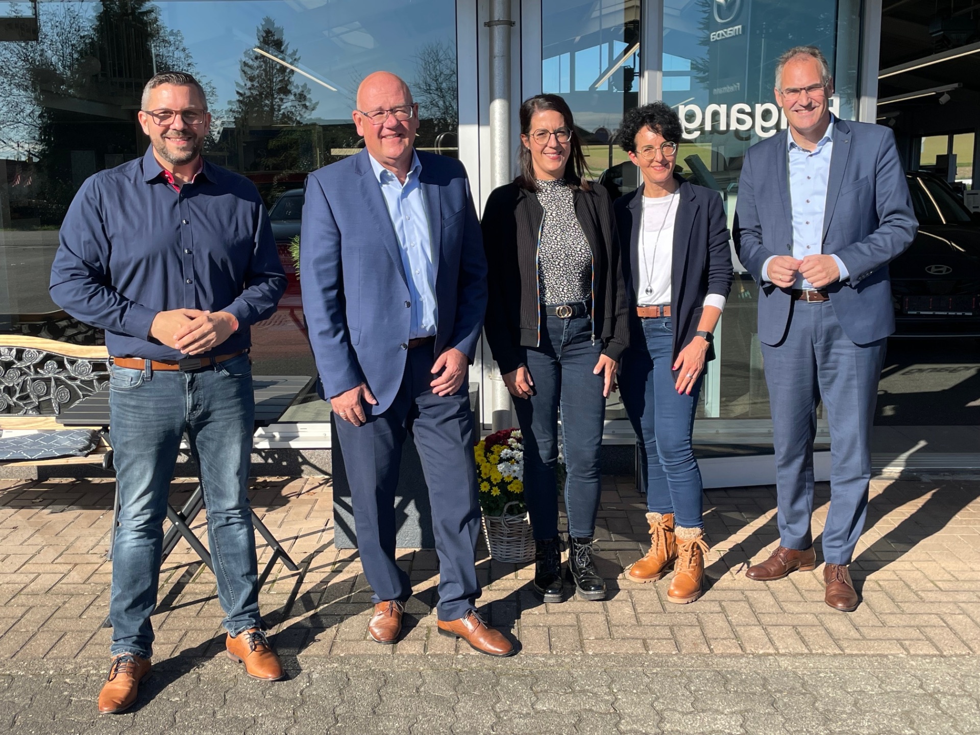 Gruppenbild vor der Glasfront des Autohaus Friedmann: Landrat Dietmar Seefeldt und MBB- Geschäftsführer Uwe König mit Geschäftsführer Sven Friedmann, Céline Scheib und Geschäftsführerin Sandra Martin.