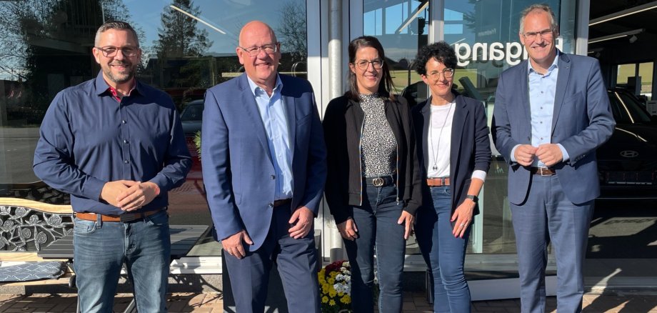 Gruppenbild vor der Glasfront des Autohaus Friedmann: Landrat Dietmar Seefeldt und MBB- Geschäftsführer Uwe König mit Geschäftsführer Sven Friedmann, Céline Scheib und Geschäftsführerin Sandra Martin.