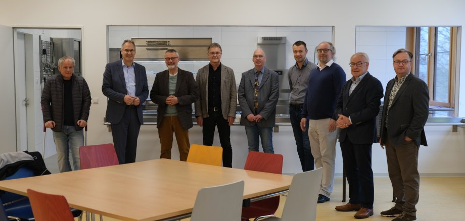 Kreisbeigeordneter Werner Schreiner, Landrat Dietmar Seefeldt, Kurt Wagenführer, Vorsitzender des Fördervereins der Realschule plus, Günter Jung, Leiter der Abteilung Bauen und Umwelt der Kreisverwaltung, Ali Daibel, Leiter der Förderschule, Leon Pabst von der Abteilung Bauen und Umwelt, Steffen Vey, Leiter der Realschule plus, Walter Schmitt, Vorsitzender des Förderkreises der Förderschule, sowie Ronny Bodenseh, stellvertretender Leiter der Schulabteilung der Kreisverwaltung stehen in der neuen Mensa und des Staufer-Schulzentrums in Annweiler am Trifels.