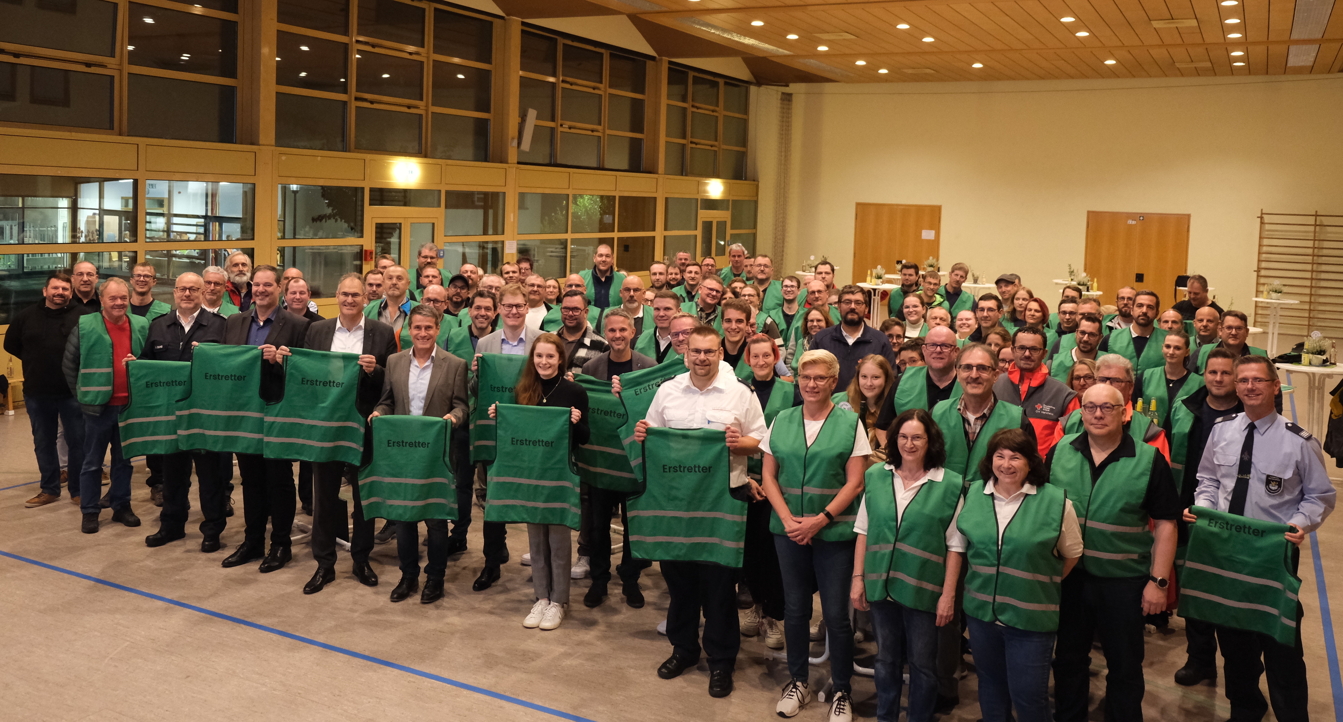 Menschen in grünen Warnwesten, die die Aufschrift  "Erstretter" tragen.