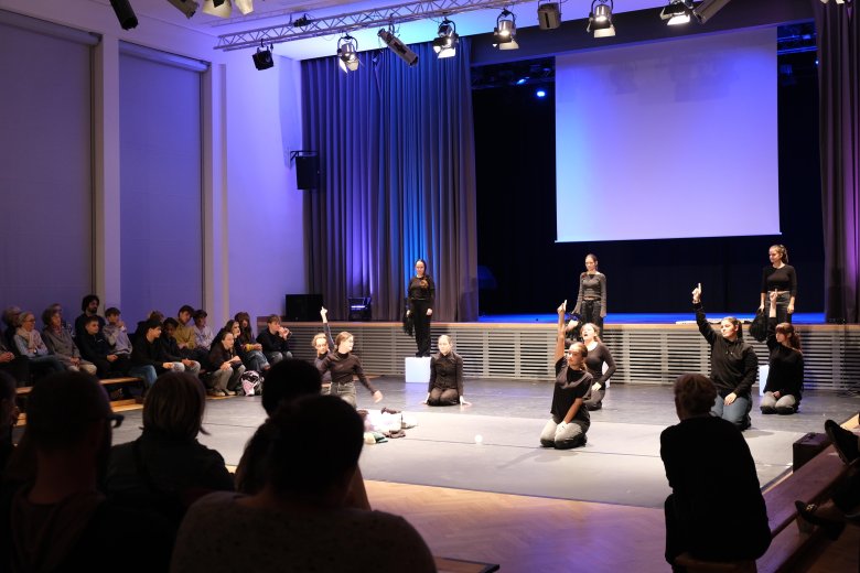 Schwarz gekleidete Jugendliche auf einer Bühne.