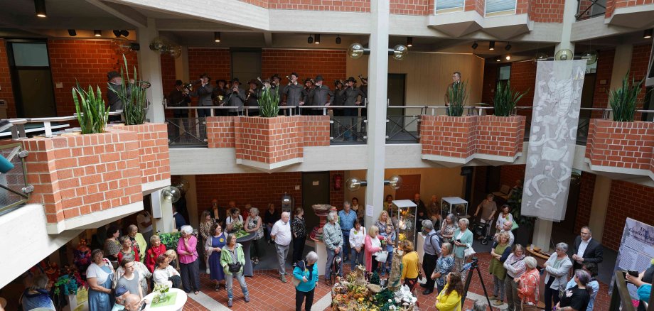 Blick auf die Gäste im Foyer der Kreisverwaltung SÜW sowie die Jagdhornbläser im ersten Obergeschoss.