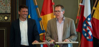 Adrian Rinck und Prof. Dr. Matthias Bahr stellten den Gästen der Preisverleihung in Weimar das Projekt vor. Foto: Maik Schuck, Weimar Adrian Rinck und Prof. Dr. Matthias Bahr präsentieren das Projekt „Youth. Europe. Music.“ während der Preisverleihung im historischen Festsaal in Weimar, in dem das politische Austauschformat des „Weimarer Dreiecks“ vor 33 Jahren gegründet wurde. Nahaufnahme der beiden am Rednerpult.