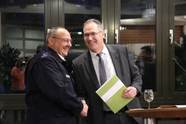 Dietmar Seefeldt (rechts) entpflichtete die Kreisjugendfeuerwehrwarte, hier mir Roland Götz. Foto: KV SÜW Landrat Dietmar Seefeldt überreicht einem Feuerwehrangehörigen in Uniform eine Urkunde und schüttelt ihm die Hand. Beide Männer lachen herzlich.