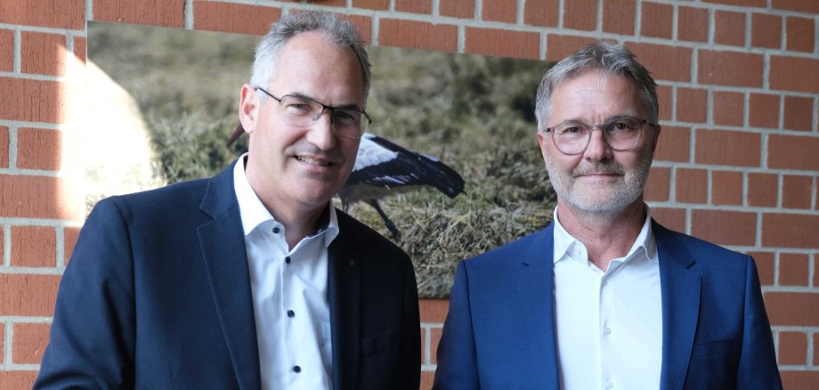 Zwei Männer, einer mit Urkunde mit SÜW-Wappen in der Hand.
