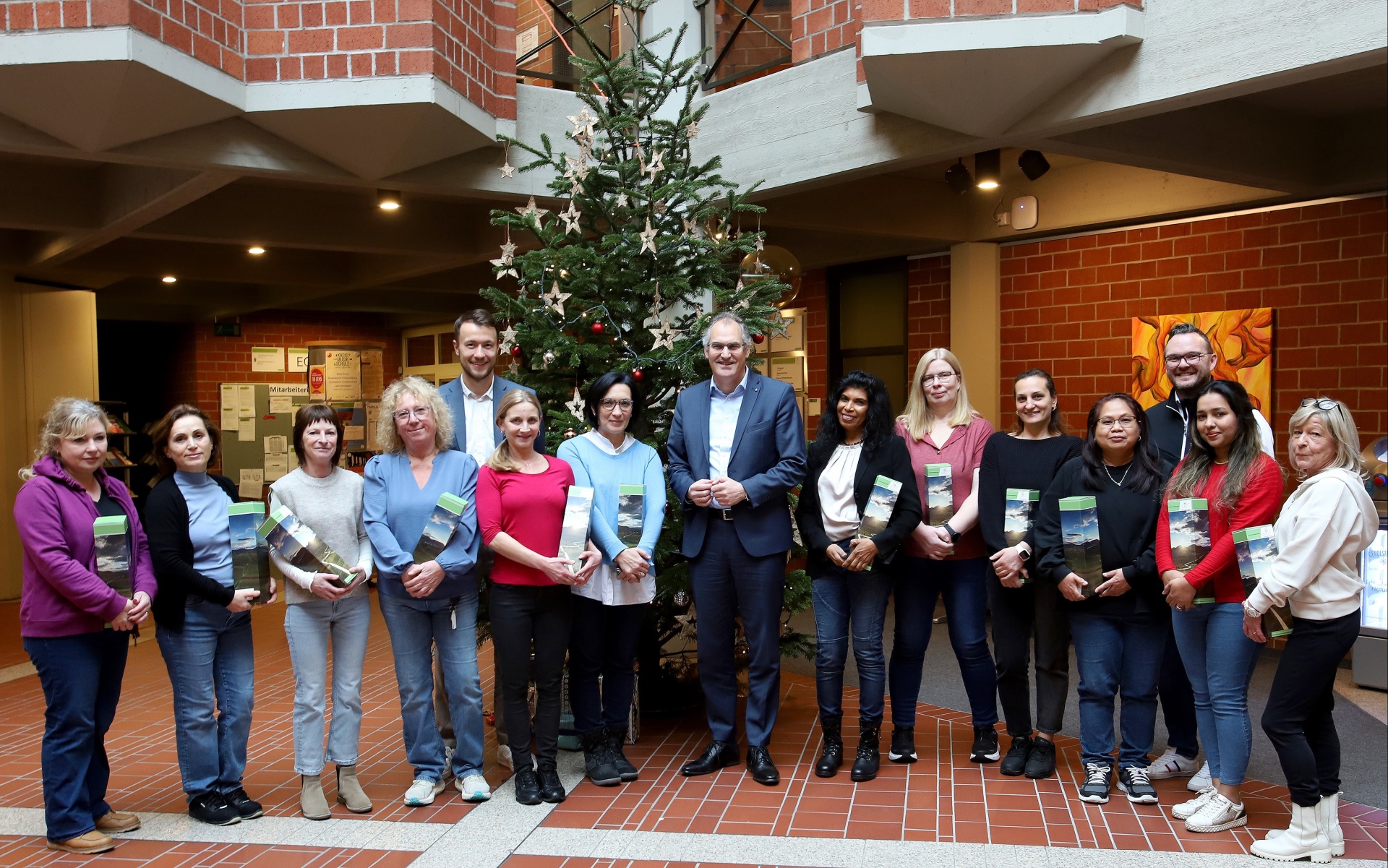 15 Personen stehen im Foyer der Kreisverwaltung vor einem Weihnachtsbaum.
