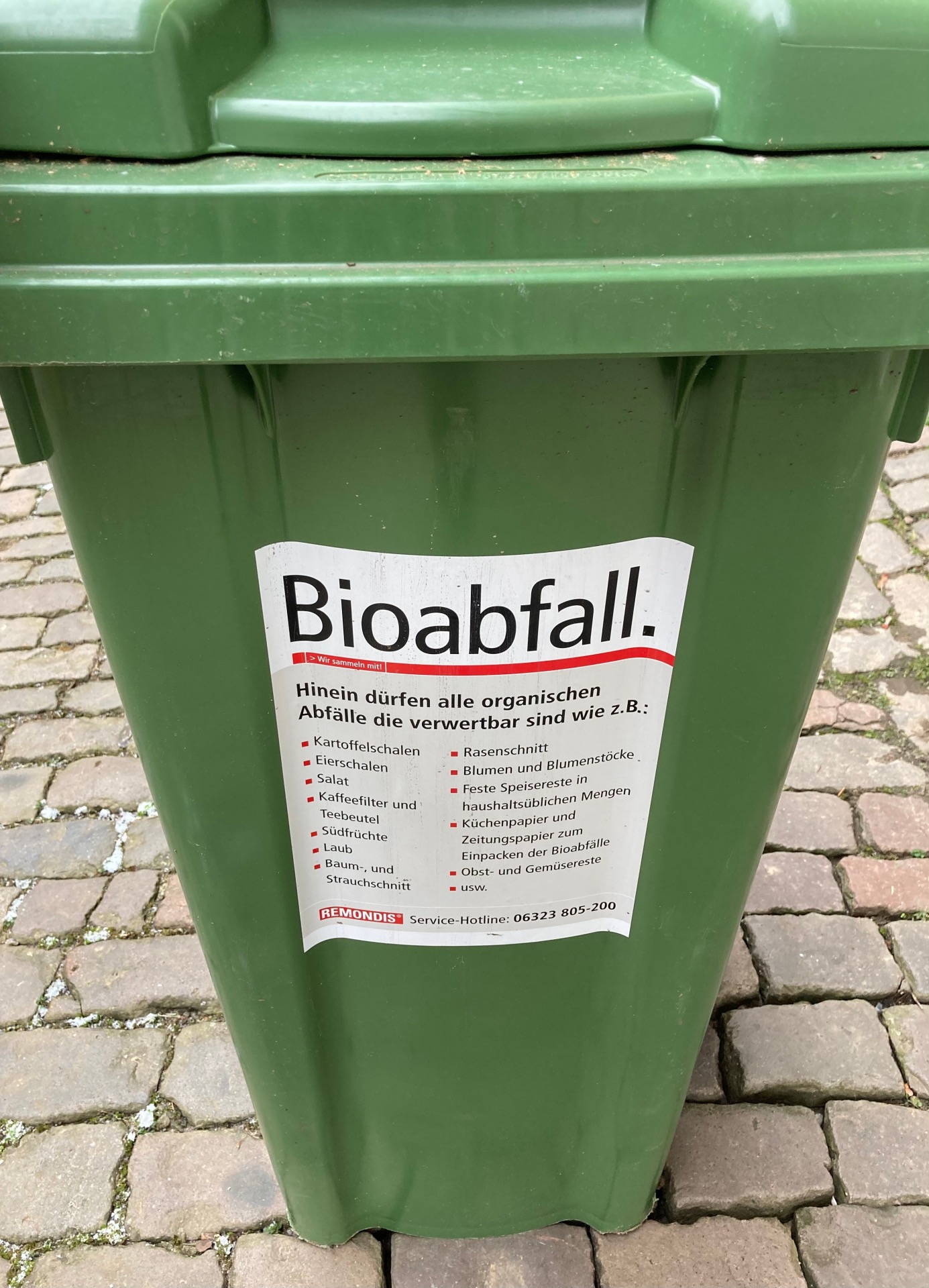 Nahaufnahme einer Biomülltonne. Ein Aufkleber listet die Abfallarten auf, die in der Tonne entsorgt werden dürfen.