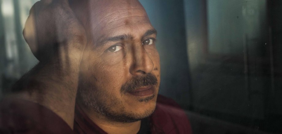 Männerdepression. Symbolfoto: Pixabay Nahaufnahme eines Mannes, der mit deprimierter Miene aus einem Fenster blickt.