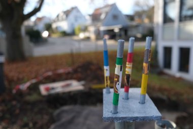 Am Anfang stand das Modell, vorne im Bild. Foto: KV SÜW Fläche mit vier nach oben ragenden kleinen Stäbchen in einer Hand, im Hintergrund unscharf eine abgesperrte Baugrube.
