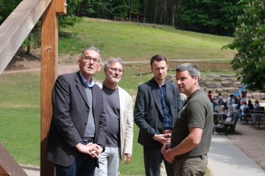 Georg Kern, Günter Jung, Leon Pabst und Daniel Kraus (von links nach rechts) besprachen den aktuellen Stand vor Ort im Wild- und Wanderpark SÜW in Silz. Foto: KV SÜW Vier Männer stehen auf einem befestigten Weg im Grünen und unterhalten sich. Im Hintergrund sind Bänke mit Besucherinnen und Besuchern zu sehen. Die Szenerie befindet sich im Wild- und Wanderpark in Silz.