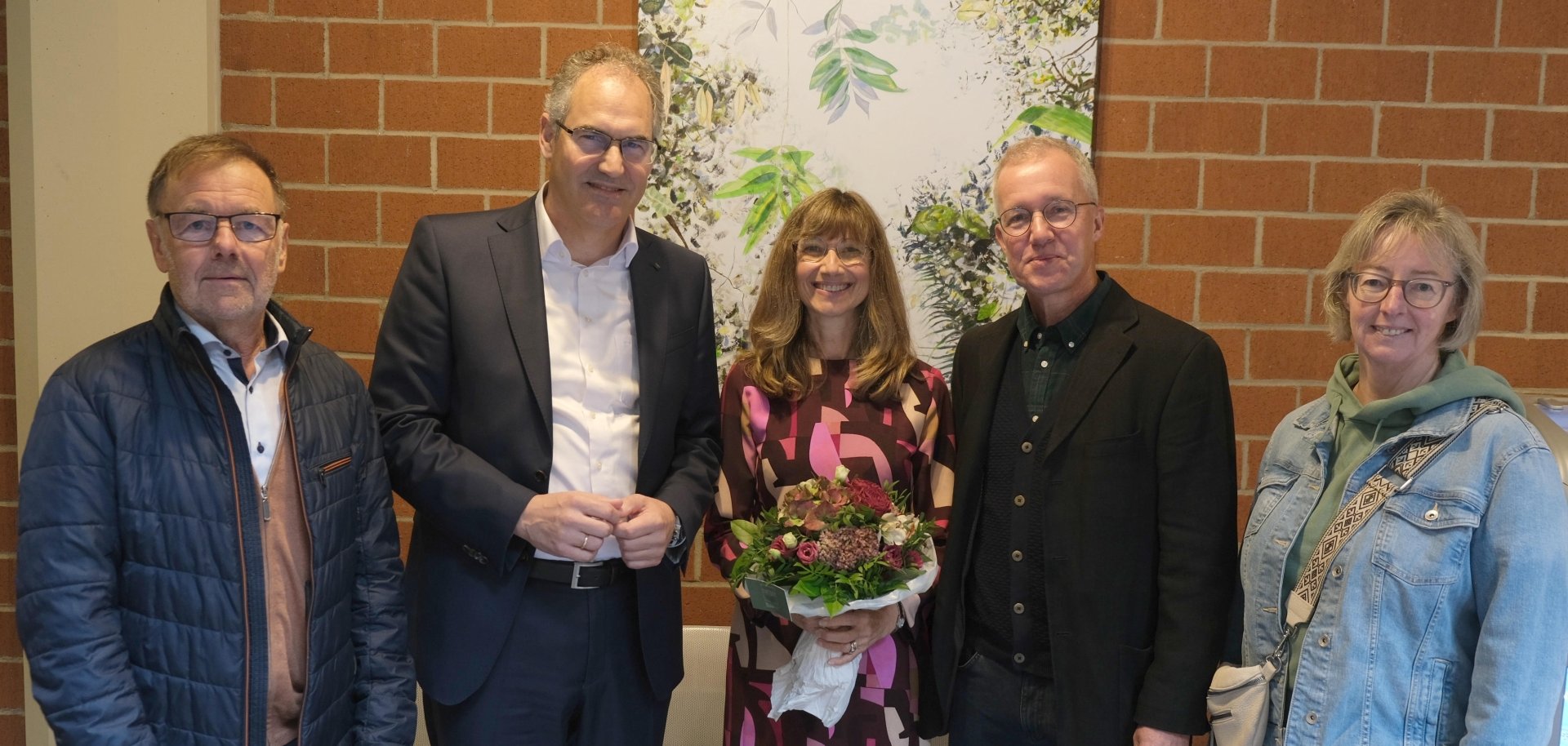 Gruppenbild: Jacklyn Gratzfeld bei der Vernissage ihrer Ausstellung im Kreishaus SÜW mit Landrat Dietmar Seefeldt und Laudator Dr. Jörg Katerndahl sowie den beiden Helfern beim Aufbau der Schau, Reinhold Klein (links) und Christine Gratzfeld .