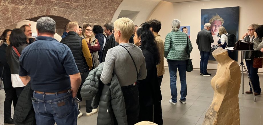 Zahlreiche Besucherinnen und Besucher bei der Vernissage zur Eröffnung der Kreiskulturtage 2025 im Museum unterm Trifels in Annweiler, umgeben von Gemälden und Skulpturen.