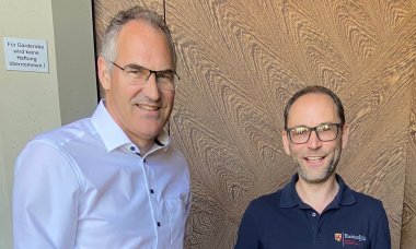 Landrat Dietmar Seefeldt (links) gratuliert Sebastian Wildmann zum Dienstjubiläum.