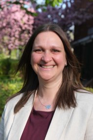 Frau vor blühenden Bäumen.