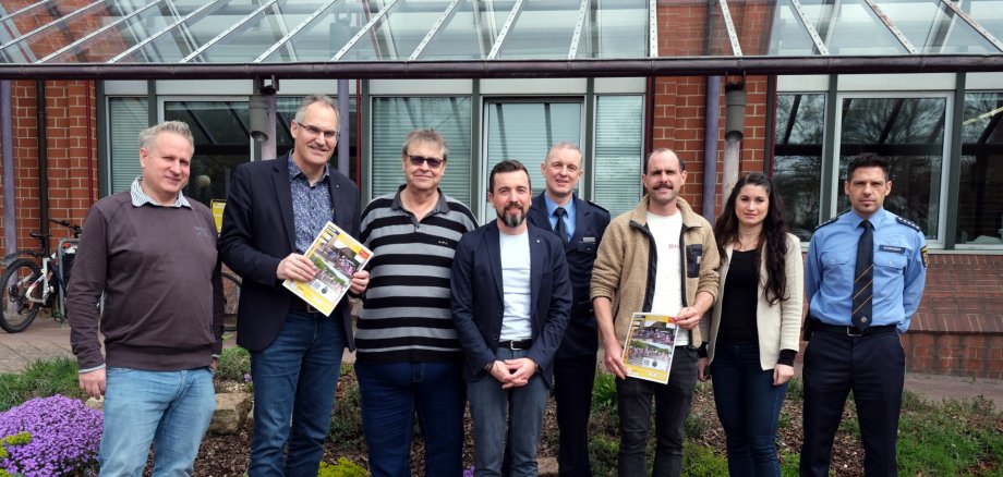 Gruppenfoto: Acht Personen stehen nebeneinander vor dem Kreishaus der Südlichen Weinstraße und lächeln in die Kamera.