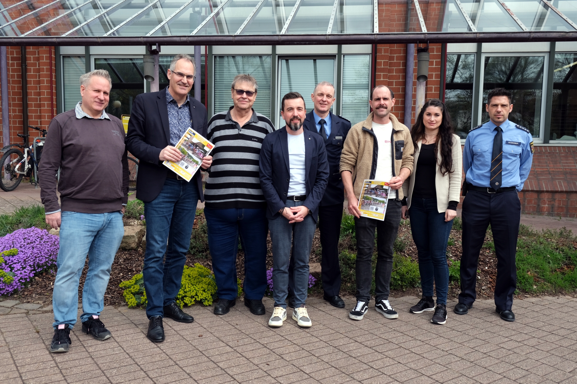 Gruppenfoto: Acht Personen stehen nebeneinander vor dem Kreishaus der Südlichen Weinstraße und lächeln in die Kamera.