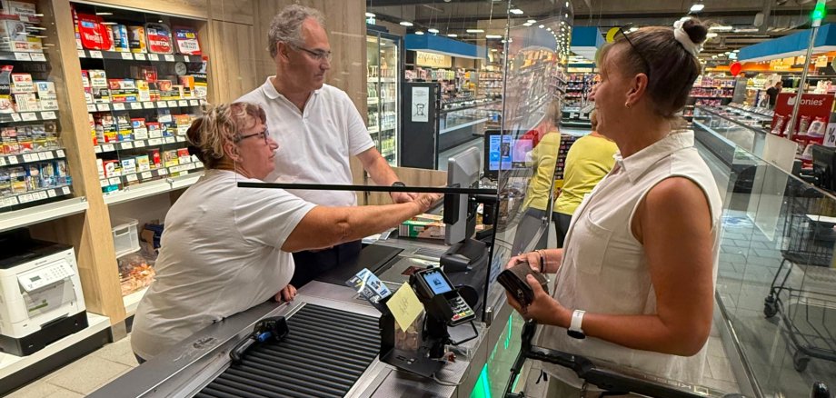 Landrat Dietmar Seefeldt hinter der Supermarktkasse im EDEKA-Kissel-SBK-Markt in Bad Bergzabern.