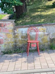 Für alle, die mal eine Pause brauchen: In Bad Bergzabern lädt ein Stuhl genau dazu ein. Foto: Zeinhom Haggag/frei Ein roter Stuhl steht auf einem Bürgersteig vor einer Mauer.